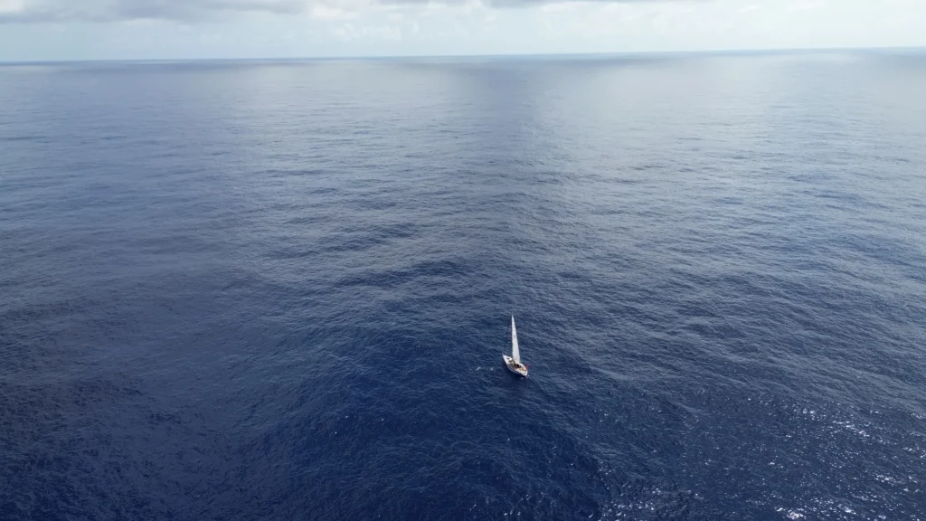 Voilier seul en pleine mer, vue aérienne : traverser l'océan sans avion