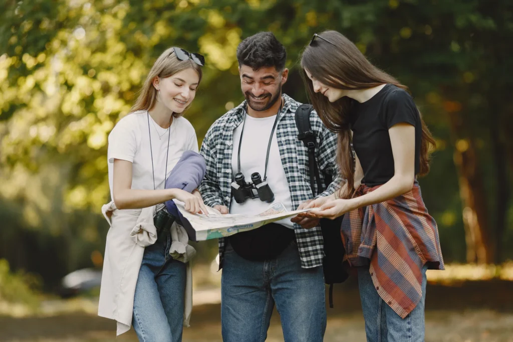 Trois amis consultent une carte pour organiser l'itinéraire de leur voyage